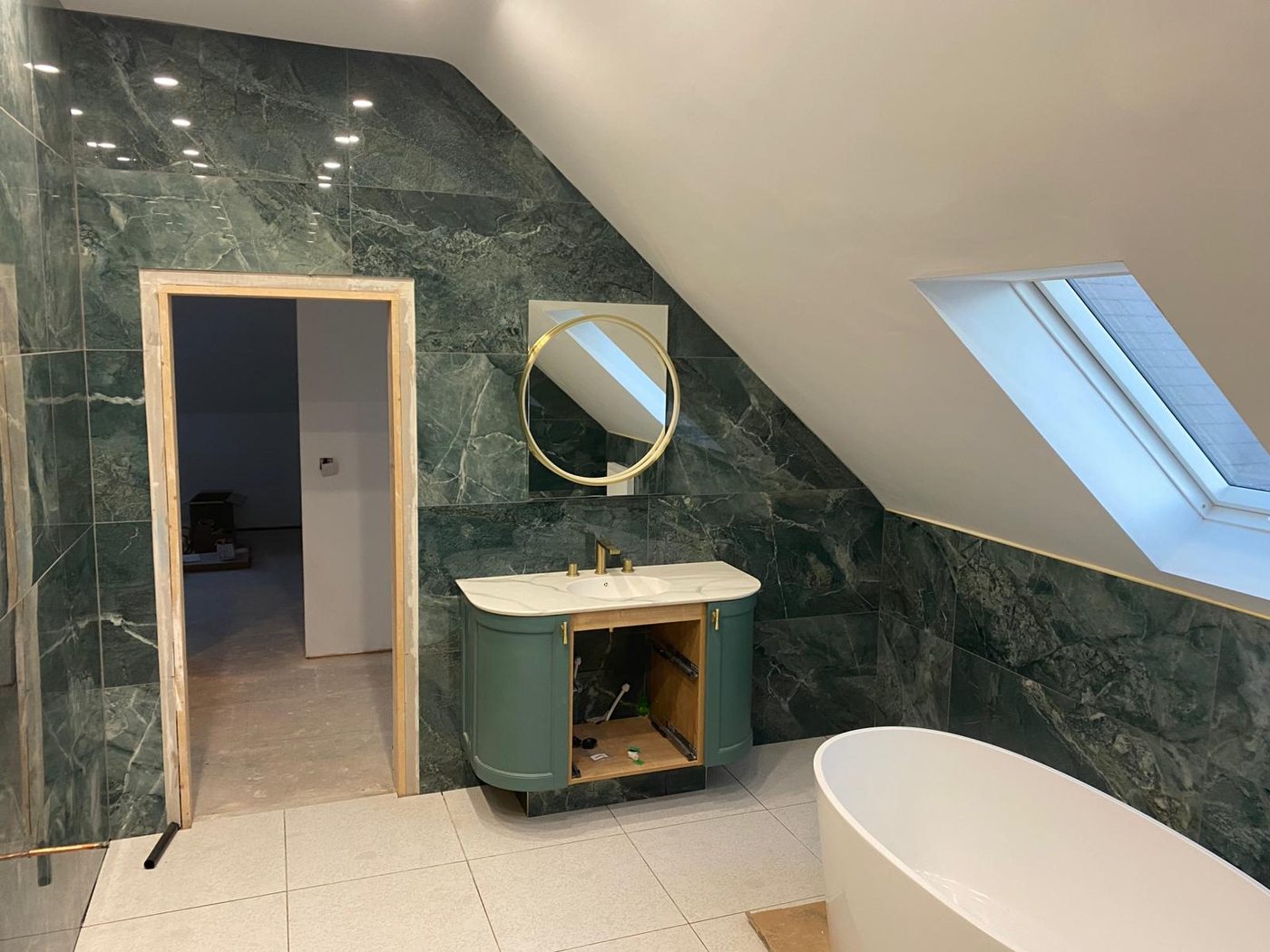 Green marble en-suite bathroom with freestanding bath
